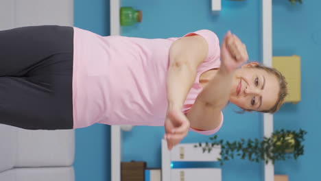 Vertical-video-of-Woman-exercising-using-her-arms.-Sports-at-home.